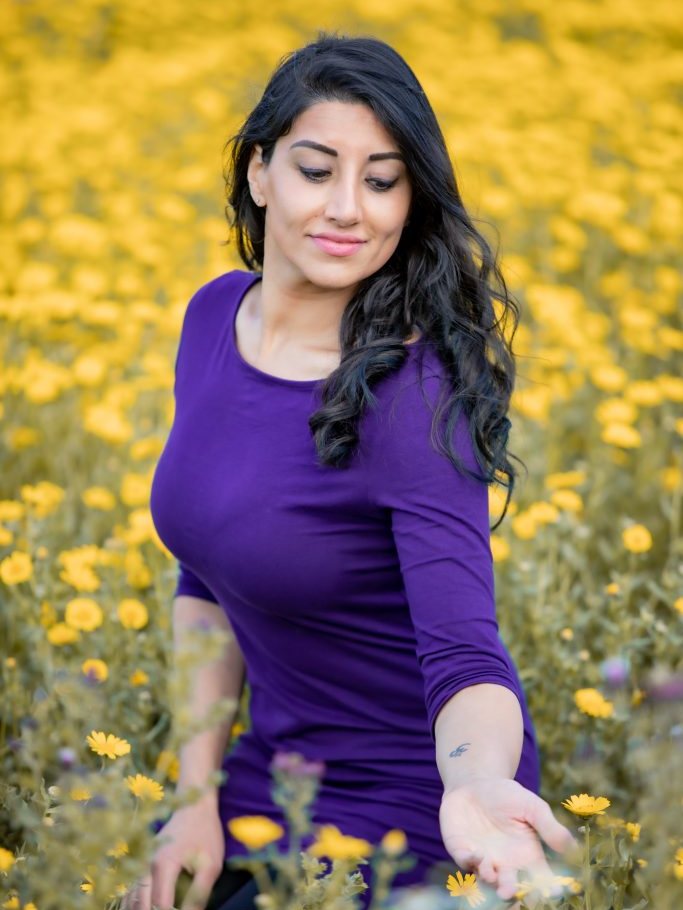Anu Verma in a field of yellow flowers